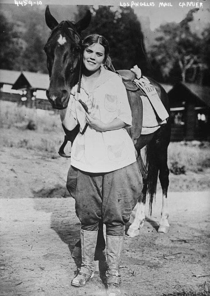 Young woman posing with a horse in an antique historical photograph showing early 20th century rural life.