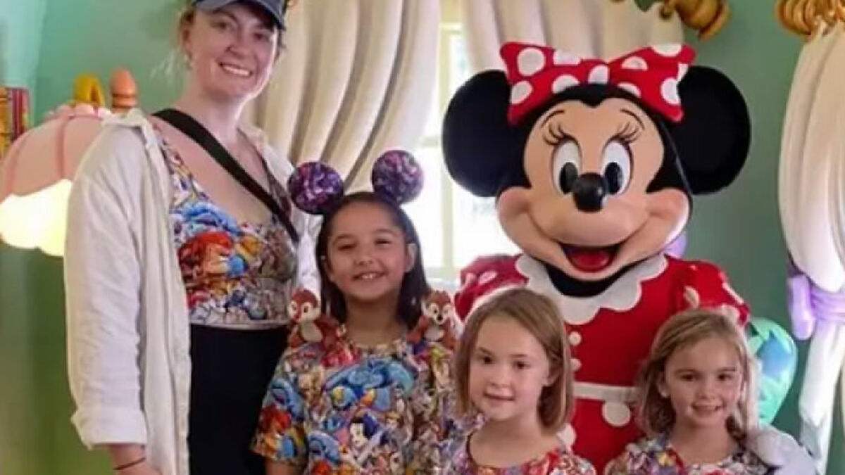 Mother and three sisters posing with Minnie Mouse at a theme park before tragic suffocation incident in the woods.