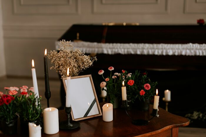 Candles and flowers arranged on a wooden table in a dim room, illustrating ethical and unethical life hacks in real world.